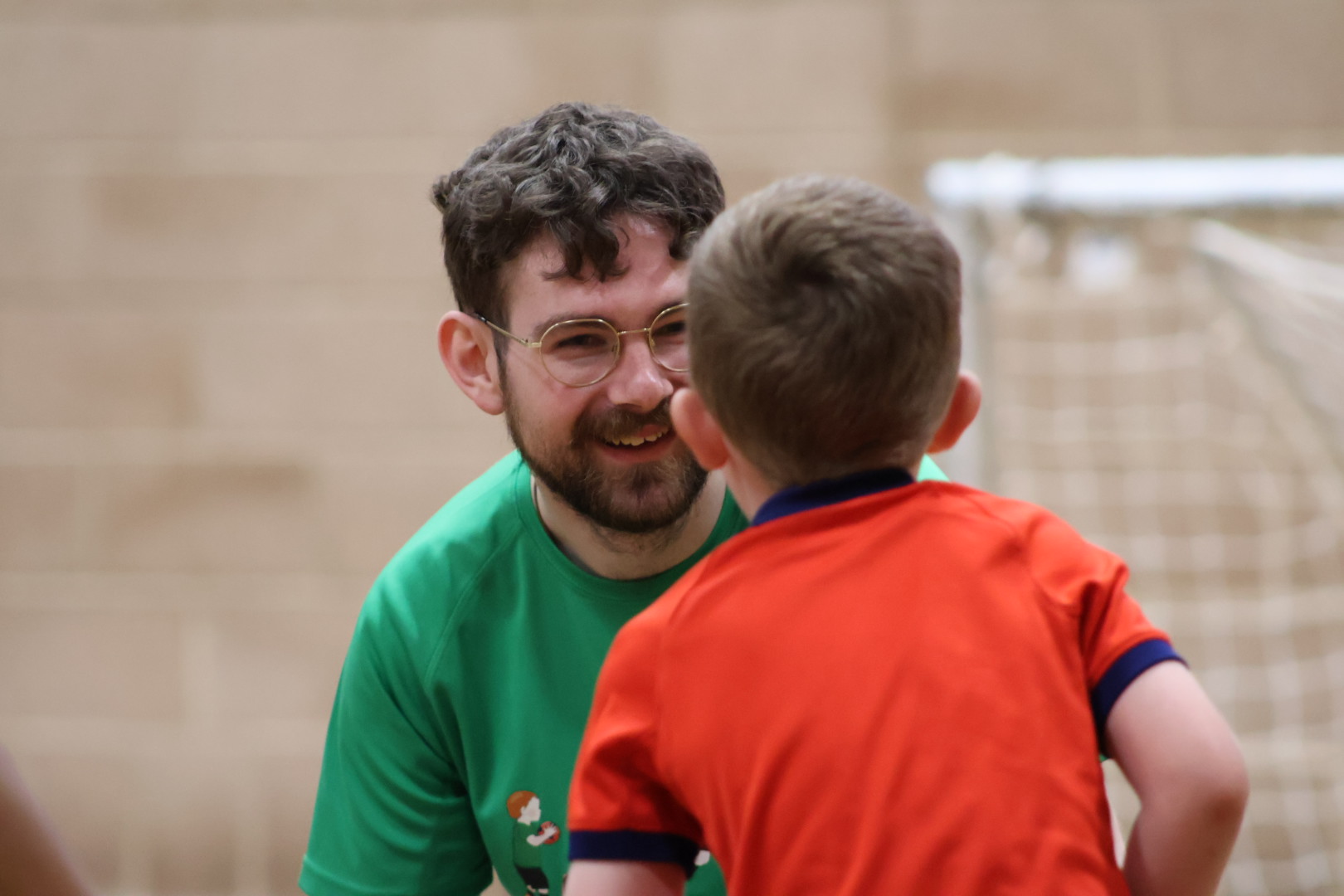 THA coach supporting players during a football session